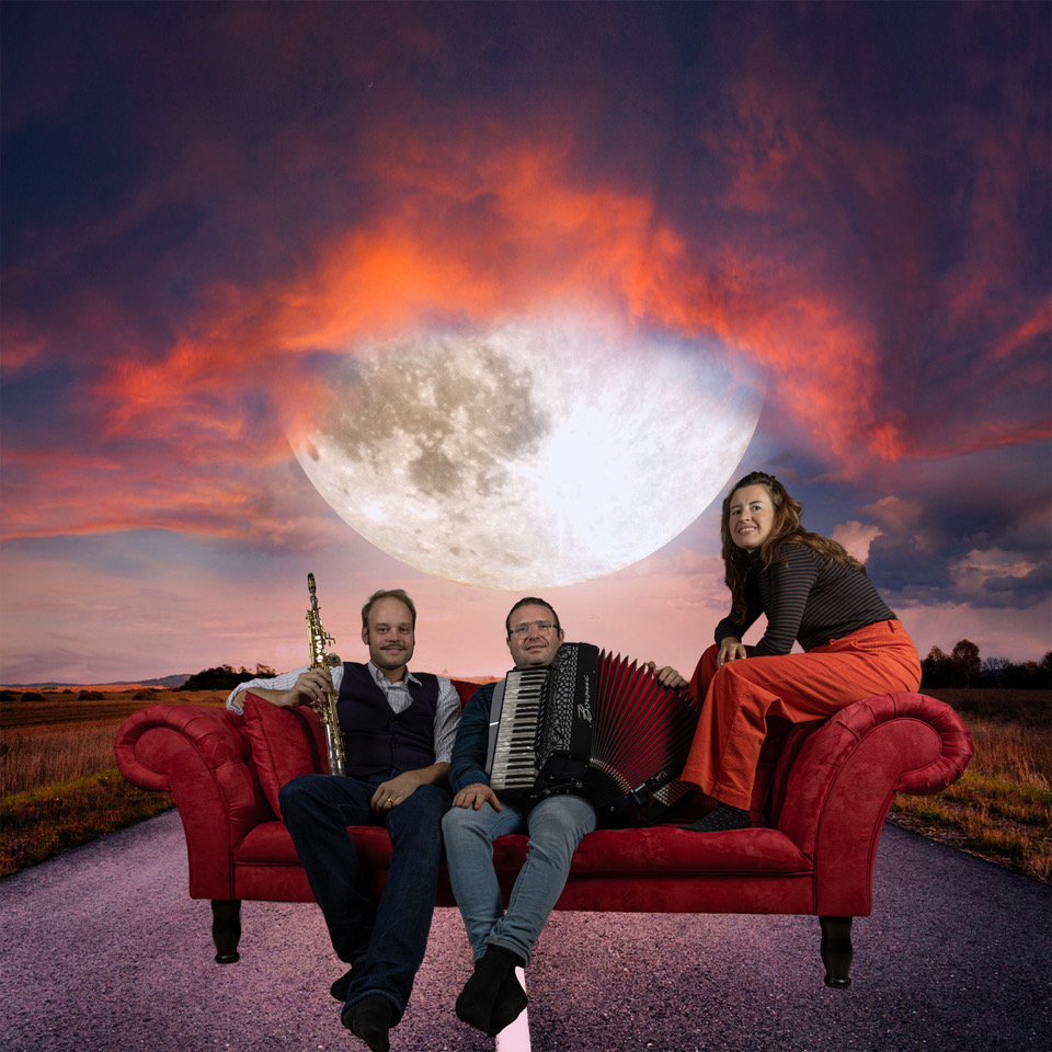 Das Trio Ohne Luft geht nix auf einem roten Sofa vor einem leuchtenden Mond